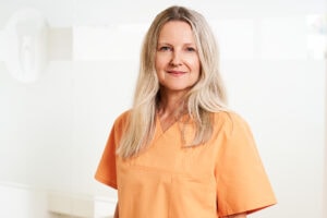 Lächelnde Zahnärztin in Praxisumgebung, spezialisiert auf Zahnmedizin in Schwabing, München.